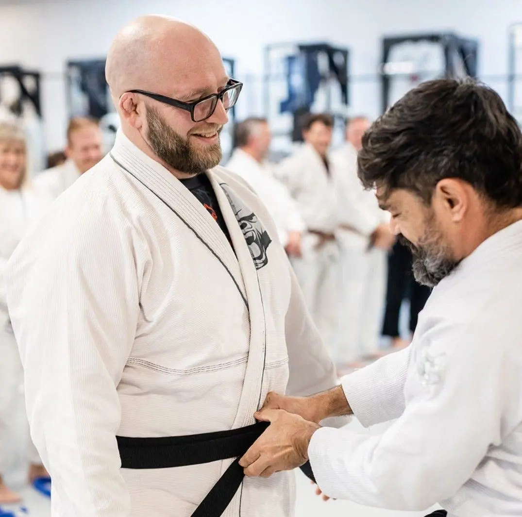 Joshua Mykitta, on the left, being promoted to Brazilian jiu-jitsu black belt by Rodney Souza, on the right